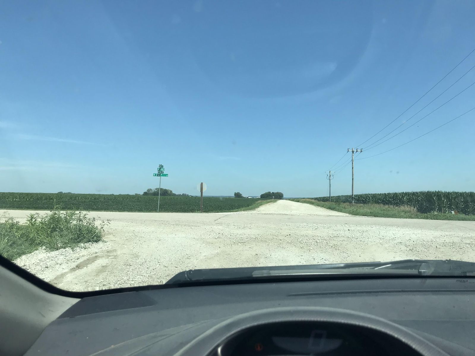 A white gravel road ahead through the windshield of the crew truck